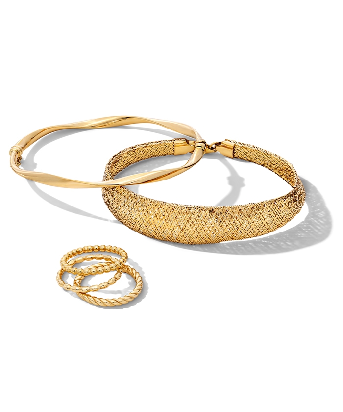 Wear stacks of gold bracelets in different colors and textures.