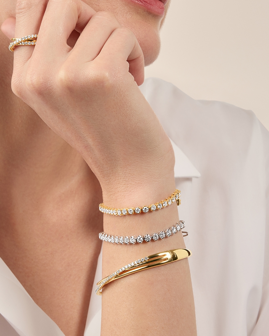Wear stacks of gold bracelets in different colors and textures.