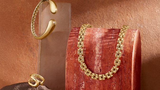 Image of bold gold looks featuring a ring, chain, and bracelet.