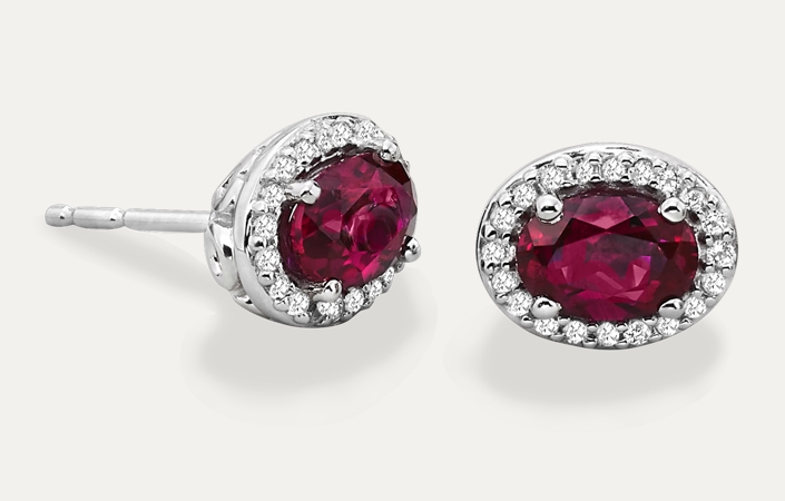 Ruby earrings set in white gold with a diamond halo. Shop ruby jewelry at Jared.