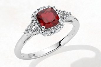 Diamond halo engagement ring with ruby center stone in white gold