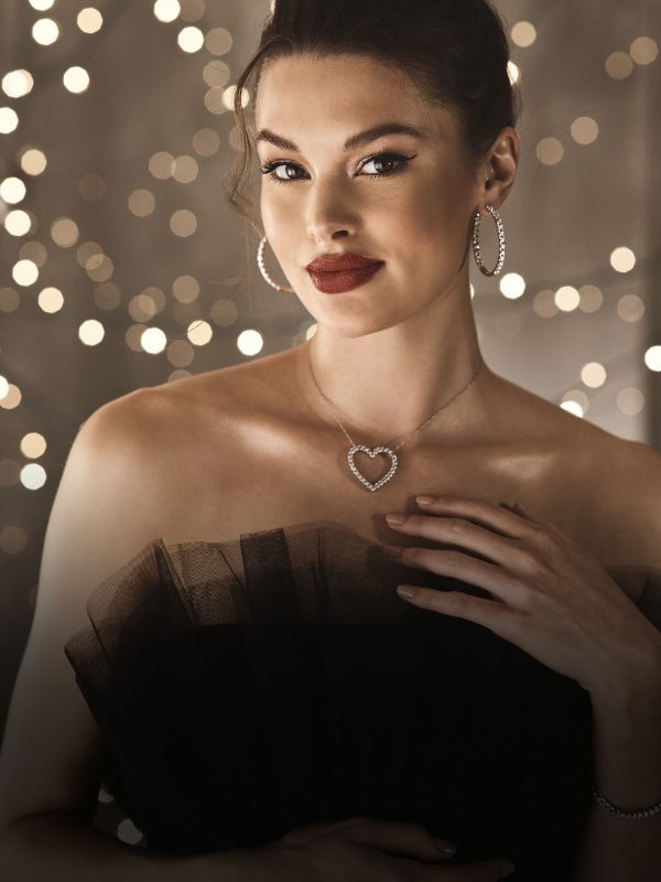 woman wearing heart necklace and hoop earrings