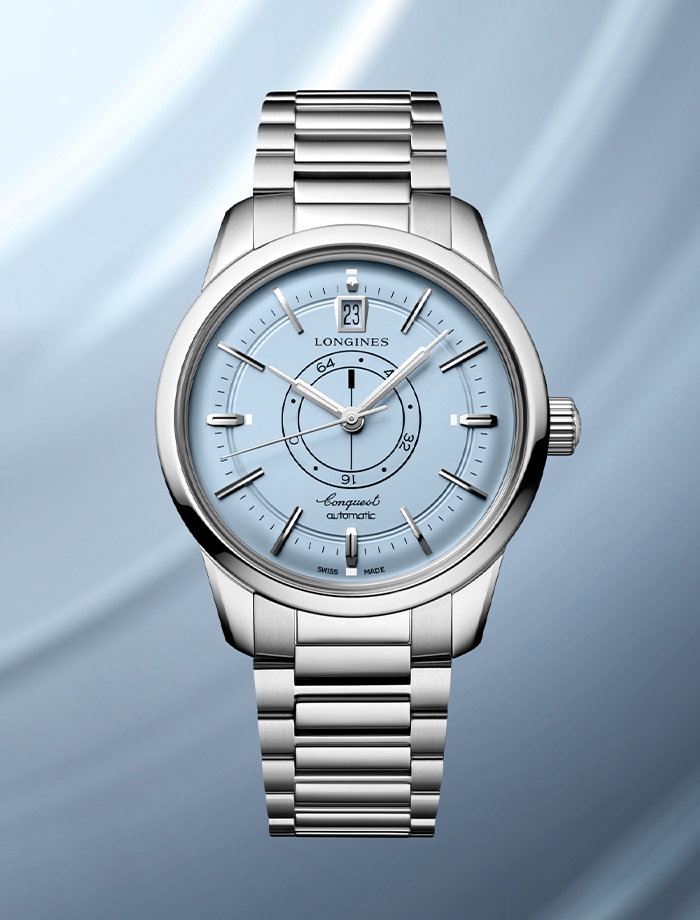 Longines Heritage watch with round black dial and stainless steel bracelet.