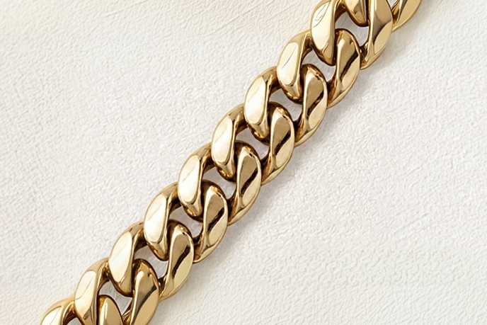 A gold Cuban necklace, also known as a curb link chain
