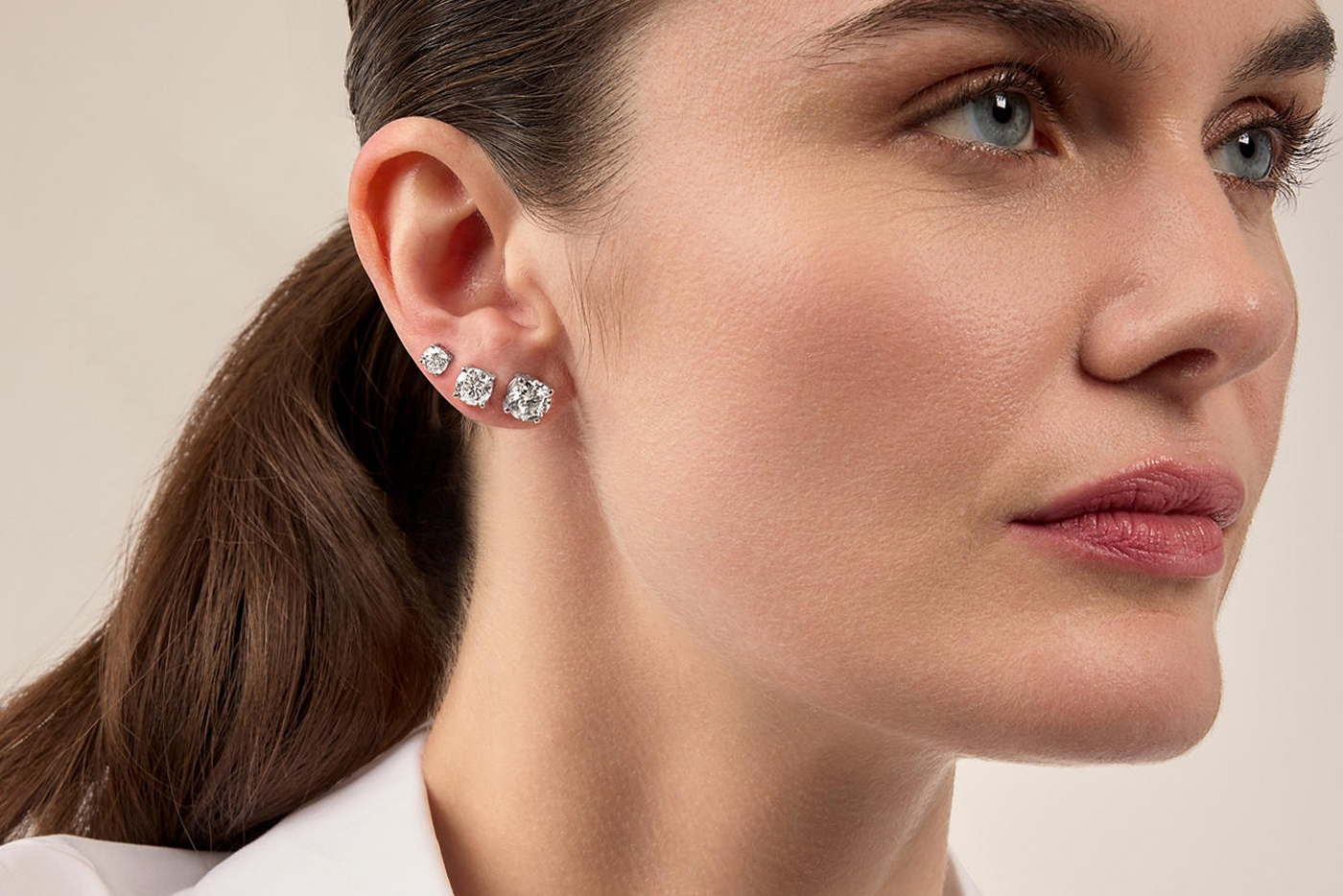 Woman modeling diamond earrings rings and bracelets