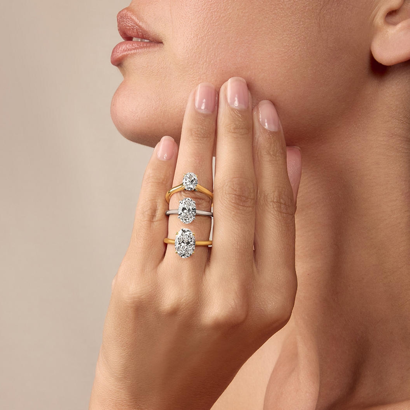 Woman modeling gold and platinum solitaire diamond rings
