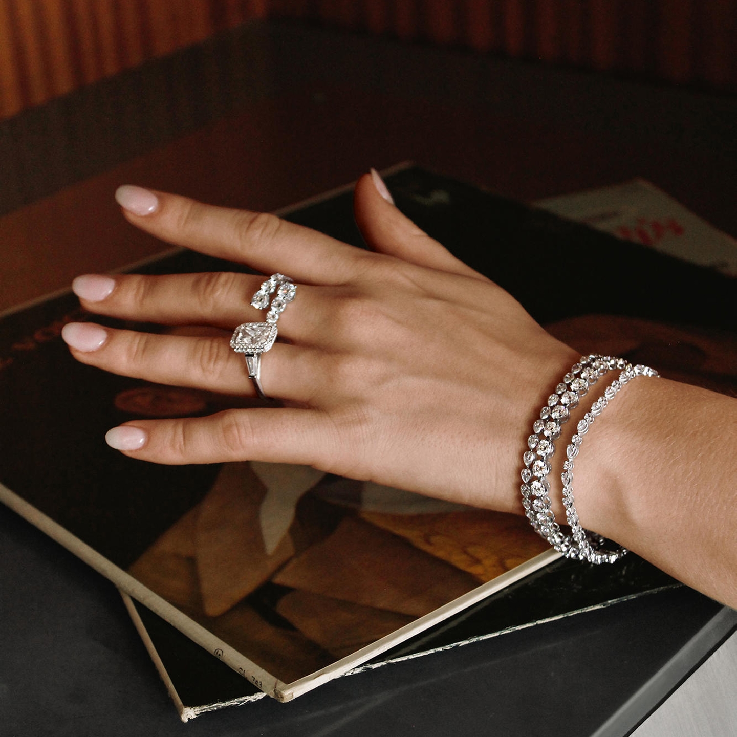 a hand with diamond rings and bracelets