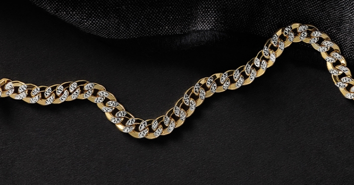 Men's yellow gold and diamond cuban link chain on a black background.