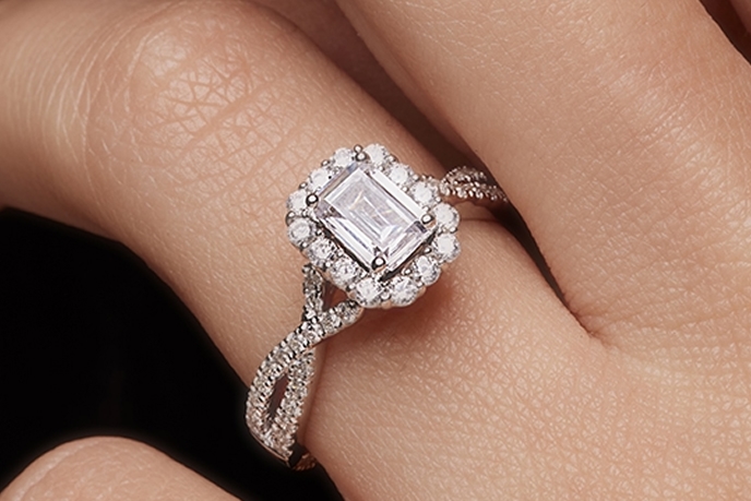 A couple holding hands wearing engagement rings.