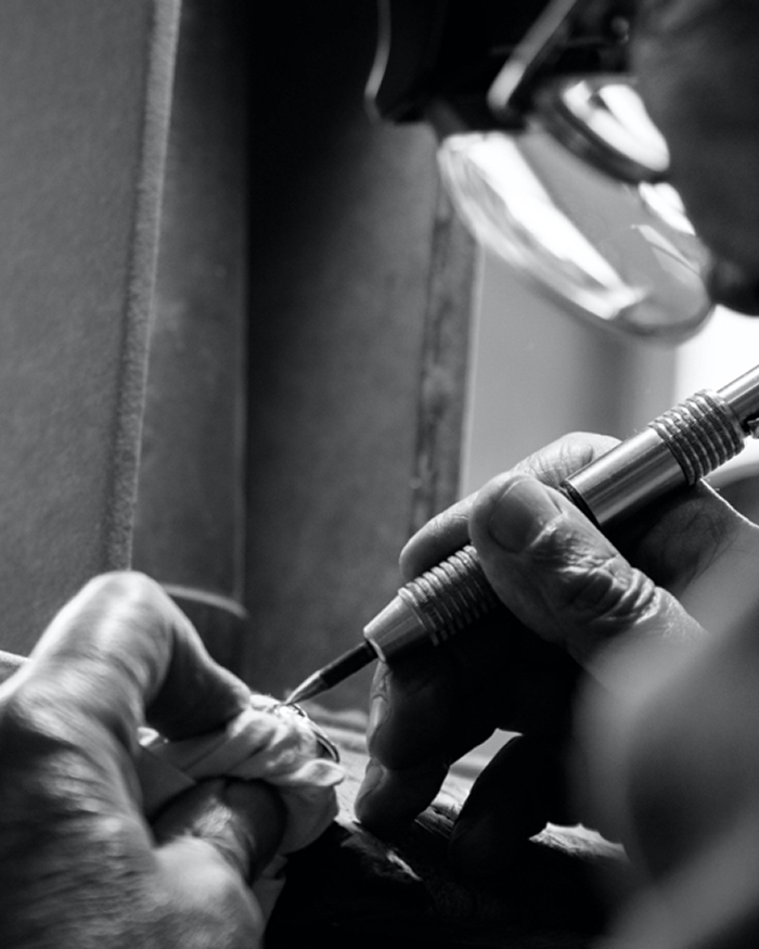 Jeweler using a tool to polish jewelry