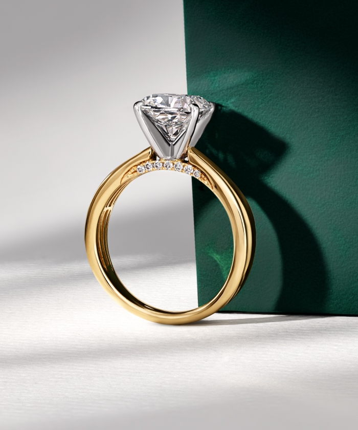 Woman's hand wearing a diamond engagement ring.