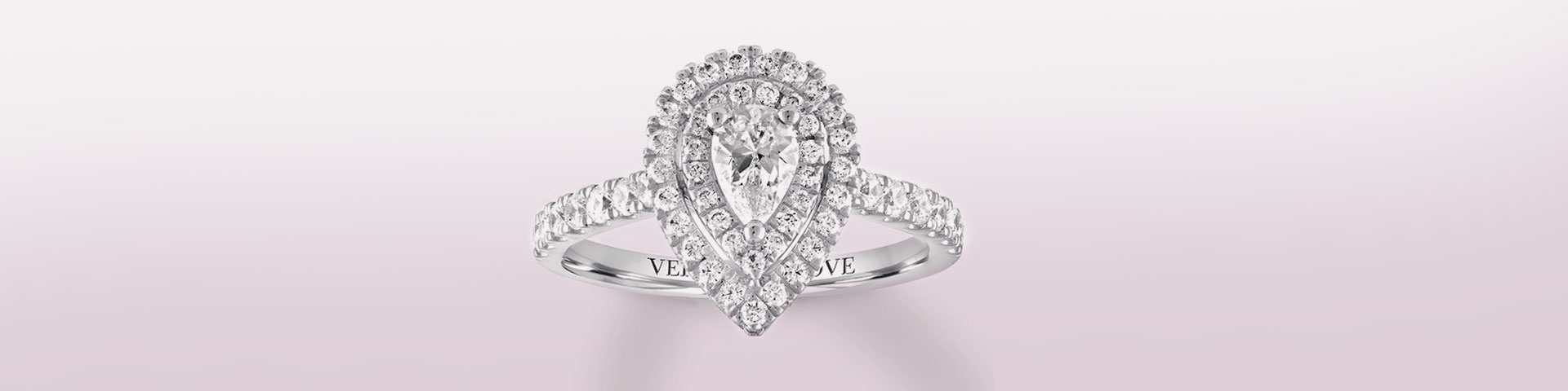 White gold and diamond engagement ring with pear-shaped center stone and round diamond halo.