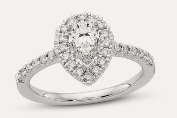 White gold engagement ring with pear-shaped center diamond and round diamond halo.