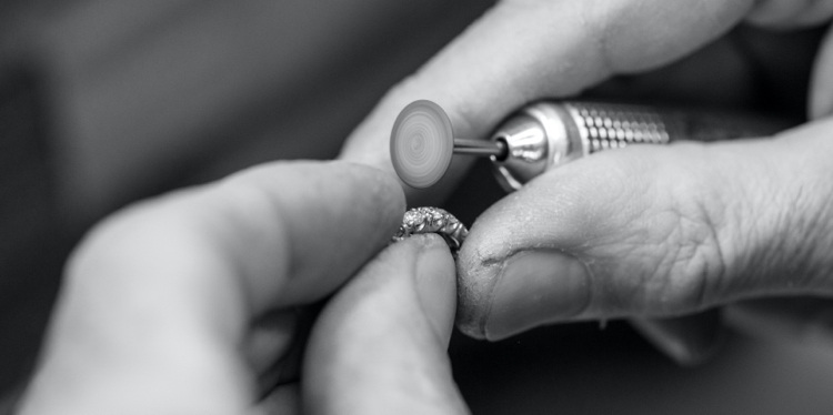 Close up shot of jewelry polishing a custom engagement ring design.