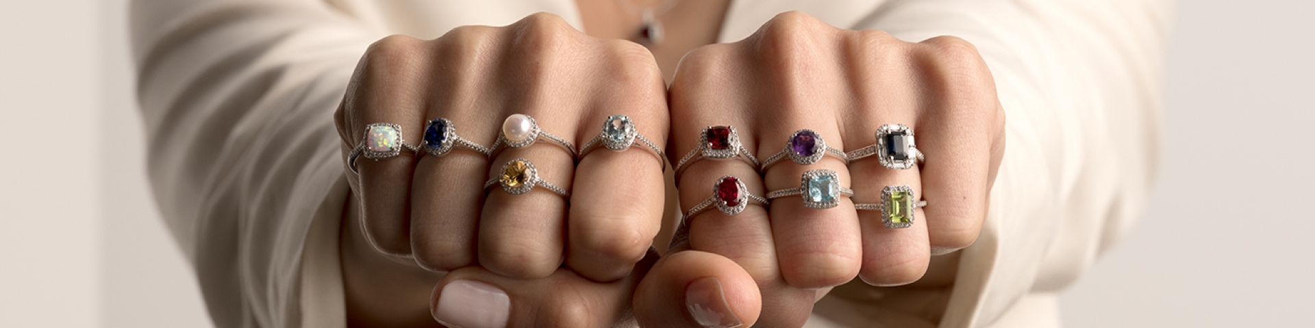 Woman wearing multiple gemstone rings on all of her fingers