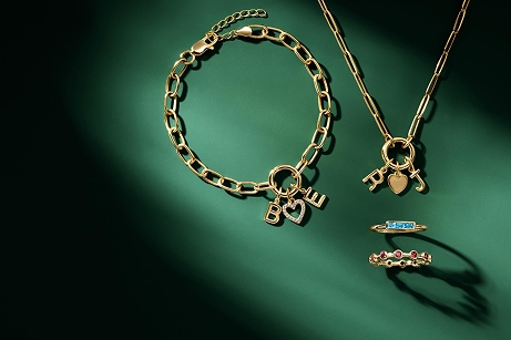 Women's yellow gold necklaces on a green background