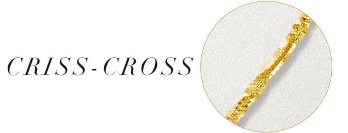 A gold criss-cross necklace against a white background.