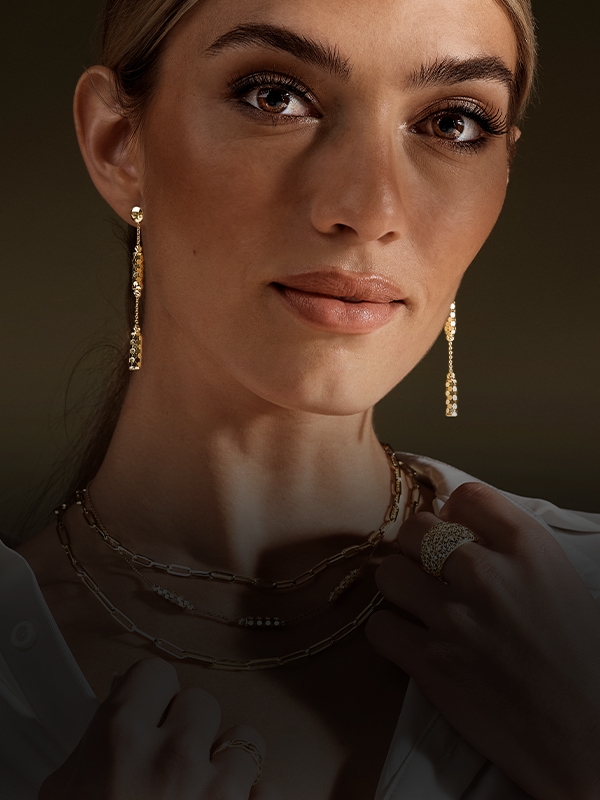 Woman wearing new gold earrings from Jared. Shop all earrings.