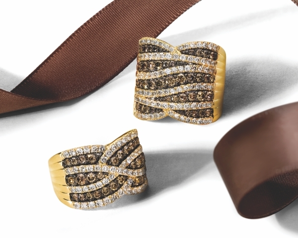 Two rings with chocolate diamonds set in honey gold with brown ribbon in background