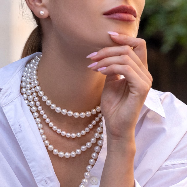 Woman wearing layered cultured pearl strands from Yoko London