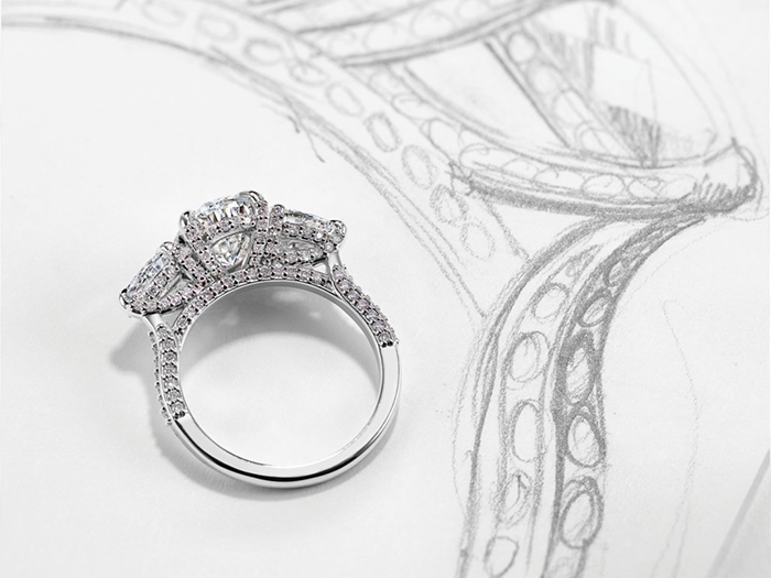 Engagement ring laying on a sketch of a ring